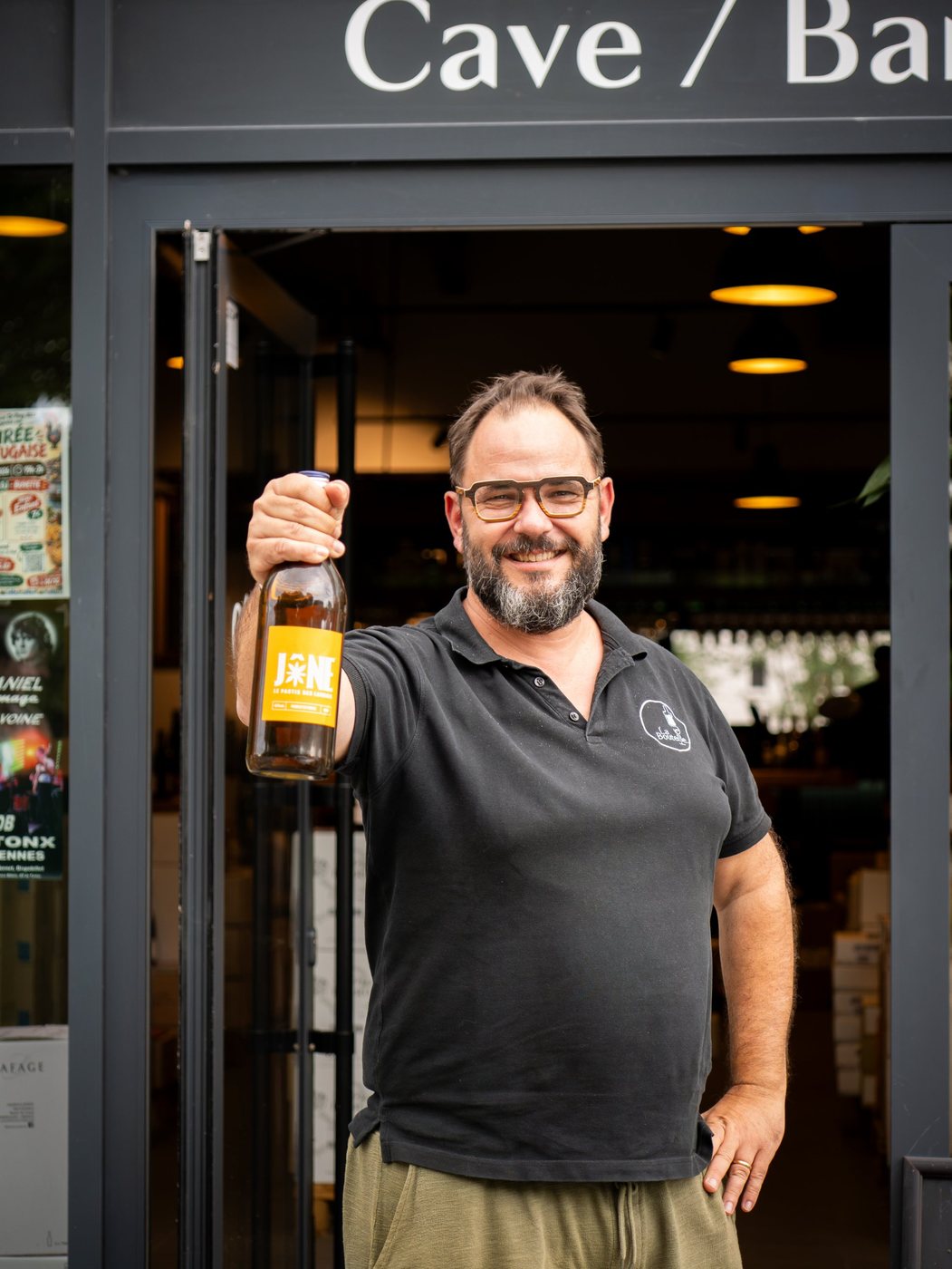 Caviste présentant une bouteille de JÔNE, le pastis des Landais